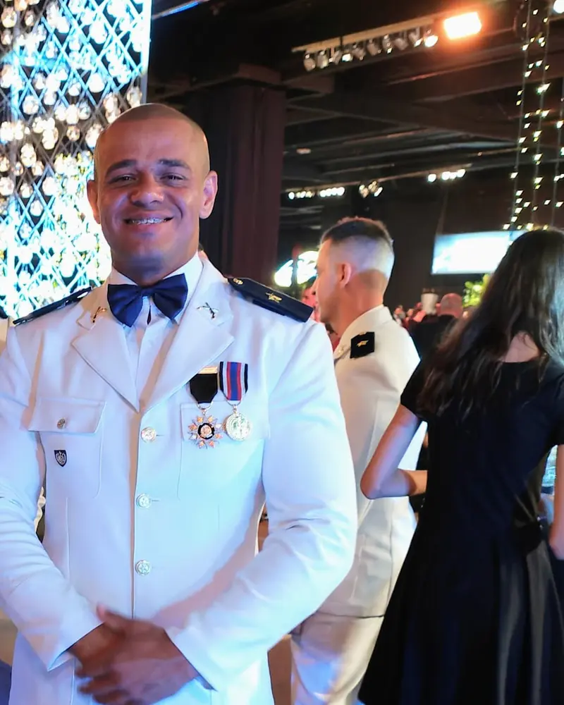 Kilder de uniforme branco de gala, com medalhas no peito, sorrindo numa cerimônia